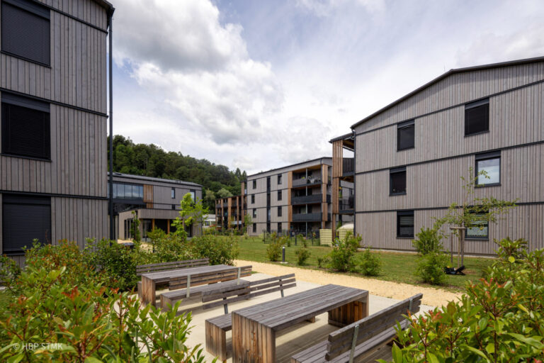 SOZIALER WOHNBAU HAT HOLZ VERDIENT BauherrIn Siedlungsgenossenschaft Ennstaler Holzbau Kulmer Bau Planung superarchitektur Statik DI Peter Rath Bauphysik rosenfelder & höfler consulting engineers Jurybegründung: Das sind Holzbauten! Klar sichtbar bekennt sich die Siedlungsgenossenschaft zum Baustoff Holz –Die Mischbauweise aus Ziegel-Massiv- und Holz-Massivbau mit Brettsperrholz ist mit seinen Fassaden als Holzbau erkennbar. Hier zeigt sich eine Siedlung auf hohem architektonischem und handwerklichem Niveau – ein Bekenntnis zu regionaler, nachhaltiger Bauwirtschaft. Sieben versetzt angeordnete Häuser mit insgesamt 63 Wohnungen garantieren Ausblick und Privatheit – Die angenehmen Wohnungsgrundrisse verfügen über gut nutzbare und wohnliche Balkone. Die Struktur der Bebauung erzeugt eine Siedlung und bleibt dabei übersichtlich, durchdacht, klar und weitgehend unversiegelt. Die Tiefgarage darunter ist nicht spürbar. Die vorgefertigten Fassaden zeigen Holzbau in sorgfältiger, hochwertiger Ausführung und tragen sichtbar zur Identität der Siedlung bei. Im Herzen der Anlage stärkt ein Gemeinschaftsraum das soziale Miteinander. Ein gelungenes Beispiel, wie sozialer Wohnbau gestalterisch und funktional überzeugt – nachhaltig, qualitätsvoll, gemeinschaftsorientiert und als Holzbau sichtbar!