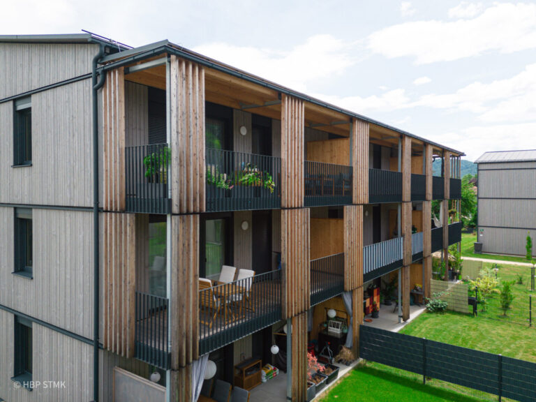 SOZIALER WOHNBAU HAT HOLZ VERDIENT BauherrIn Siedlungsgenossenschaft Ennstaler Holzbau Kulmer Bau Planung superarchitektur Statik DI Peter Rath Bauphysik rosenfelder & höfler consulting engineers Jurybegründung: Das sind Holzbauten! Klar sichtbar bekennt sich die Siedlungsgenossenschaft zum Baustoff Holz –Die Mischbauweise aus Ziegel-Massiv- und Holz-Massivbau mit Brettsperrholz ist mit seinen Fassaden als Holzbau erkennbar. Hier zeigt sich eine Siedlung auf hohem architektonischem und handwerklichem Niveau – ein Bekenntnis zu regionaler, nachhaltiger Bauwirtschaft. Sieben versetzt angeordnete Häuser mit insgesamt 63 Wohnungen garantieren Ausblick und Privatheit – Die angenehmen Wohnungsgrundrisse verfügen über gut nutzbare und wohnliche Balkone. Die Struktur der Bebauung erzeugt eine Siedlung und bleibt dabei übersichtlich, durchdacht, klar und weitgehend unversiegelt. Die Tiefgarage darunter ist nicht spürbar. Die vorgefertigten Fassaden zeigen Holzbau in sorgfältiger, hochwertiger Ausführung und tragen sichtbar zur Identität der Siedlung bei. Im Herzen der Anlage stärkt ein Gemeinschaftsraum das soziale Miteinander. Ein gelungenes Beispiel, wie sozialer Wohnbau gestalterisch und funktional überzeugt – nachhaltig, qualitätsvoll, gemeinschaftsorientiert und als Holzbau sichtbar!