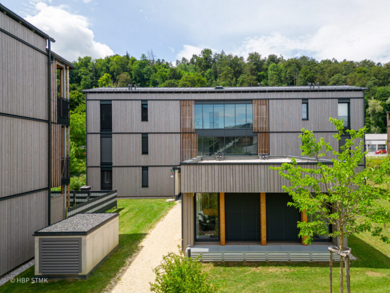 SOZIALER WOHNBAU HAT HOLZ VERDIENT BauherrIn Siedlungsgenossenschaft Ennstaler Holzbau Kulmer Bau Planung superarchitektur Statik DI Peter Rath Bauphysik rosenfelder & höfler consulting engineers Jurybegründung: Das sind Holzbauten! Klar sichtbar bekennt sich die Siedlungsgenossenschaft zum Baustoff Holz –Die Mischbauweise aus Ziegel-Massiv- und Holz-Massivbau mit Brettsperrholz ist mit seinen Fassaden als Holzbau erkennbar. Hier zeigt sich eine Siedlung auf hohem architektonischem und handwerklichem Niveau – ein Bekenntnis zu regionaler, nachhaltiger Bauwirtschaft. Sieben versetzt angeordnete Häuser mit insgesamt 63 Wohnungen garantieren Ausblick und Privatheit – Die angenehmen Wohnungsgrundrisse verfügen über gut nutzbare und wohnliche Balkone. Die Struktur der Bebauung erzeugt eine Siedlung und bleibt dabei übersichtlich, durchdacht, klar und weitgehend unversiegelt. Die Tiefgarage darunter ist nicht spürbar. Die vorgefertigten Fassaden zeigen Holzbau in sorgfältiger, hochwertiger Ausführung und tragen sichtbar zur Identität der Siedlung bei. Im Herzen der Anlage stärkt ein Gemeinschaftsraum das soziale Miteinander. Ein gelungenes Beispiel, wie sozialer Wohnbau gestalterisch und funktional überzeugt – nachhaltig, qualitätsvoll, gemeinschaftsorientiert und als Holzbau sichtbar!